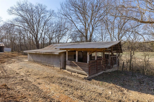 view of side of property featuring metal roof and an outbuilding