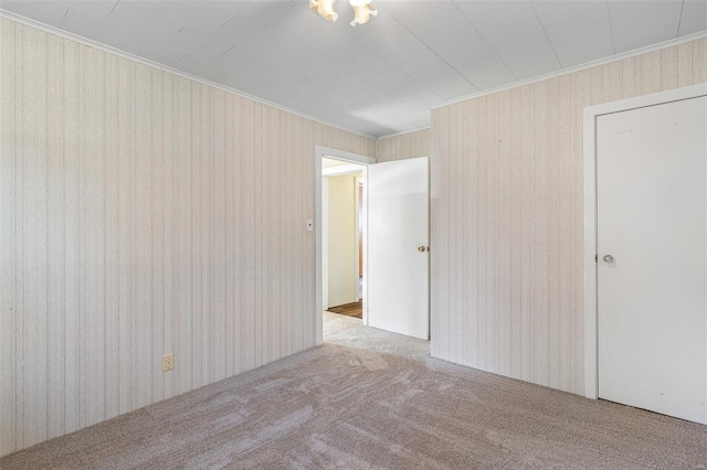 unfurnished room featuring carpet floors, ornamental molding, and wallpapered walls