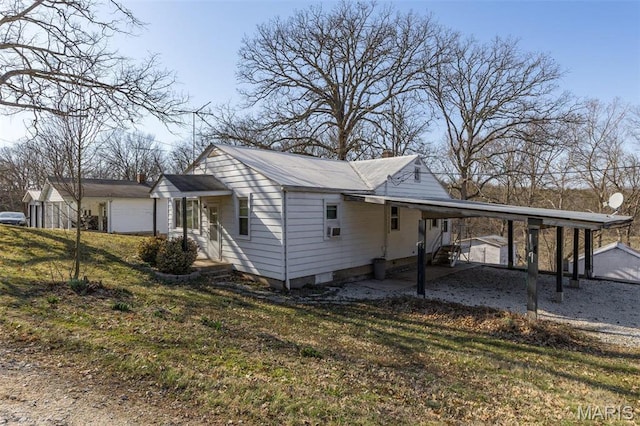 699 Clement Rd, Bloomsdale, MO 63627 - view of home's exterior featuring an attached carport, a chimney, a lawn, and driveway
