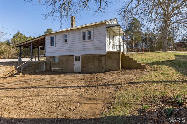 699 Clement Rd, Bloomsdale, MO 63627 - back of property featuring stairway, a chimney, a lawn, and a carport