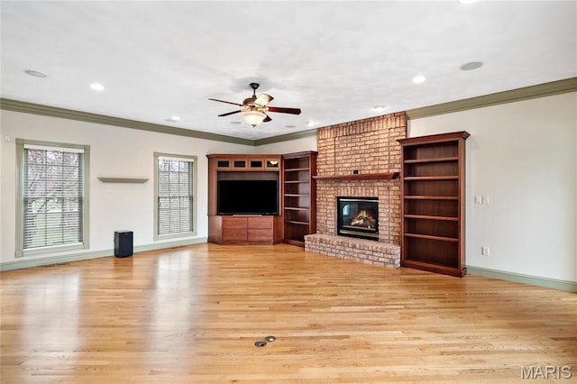 unfurnished living room featuring crown molding, light wood-style floors, a ceiling fan, a brick fireplace, and plenty of natural light