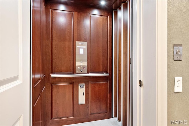 elevator featuring a textured wall