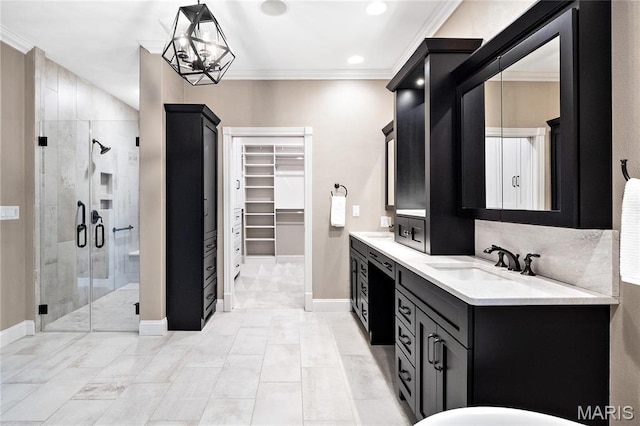 bathroom with a shower stall, crown molding, a walk in closet, double vanity, and baseboards