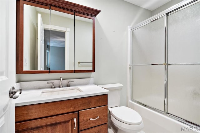 full bathroom featuring toilet, vanity, and bath / shower combo with glass door