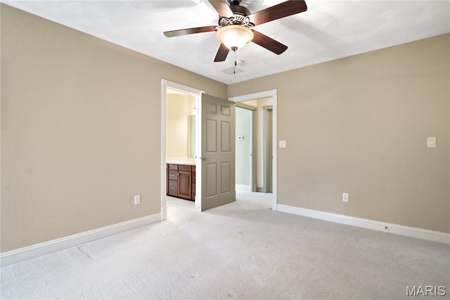 spare room with ceiling fan, light colored carpet, and baseboards