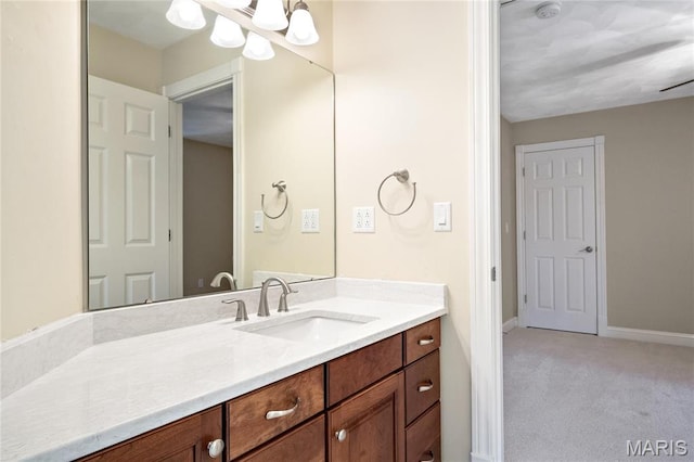bathroom featuring vanity, baseboards, and a chandelier