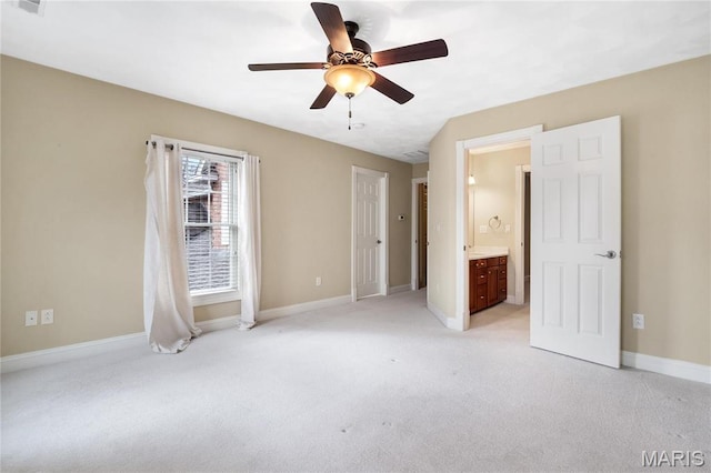unfurnished bedroom featuring light colored carpet, baseboards, ensuite bath, and ceiling fan