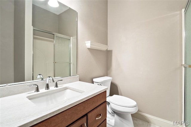 full bathroom with toilet, vanity, a shower with shower door, baseboards, and tile patterned flooring