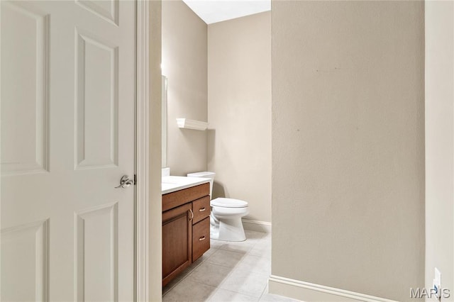 bathroom with vanity, baseboards, toilet, and tile patterned flooring
