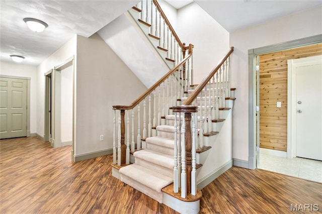stairs featuring wood finished floors and baseboards