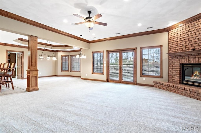 unfurnished living room with light colored carpet, decorative columns, baseboards, a brick fireplace, and crown molding