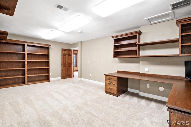 unfurnished office featuring built in study area, light carpet, baseboards, and attic access