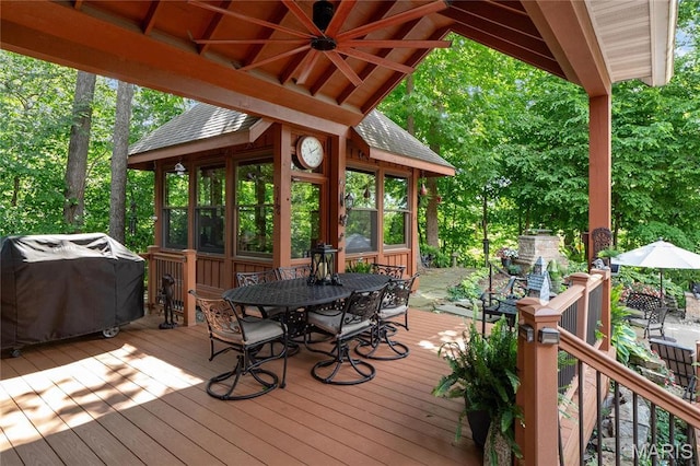 deck featuring outdoor dining space, a grill, and ceiling fan