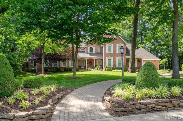 view of front of property featuring a front lawn and brick siding