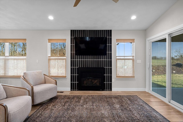 living room with wood finished floors, baseboards, recessed lighting, a fireplace, and ceiling fan