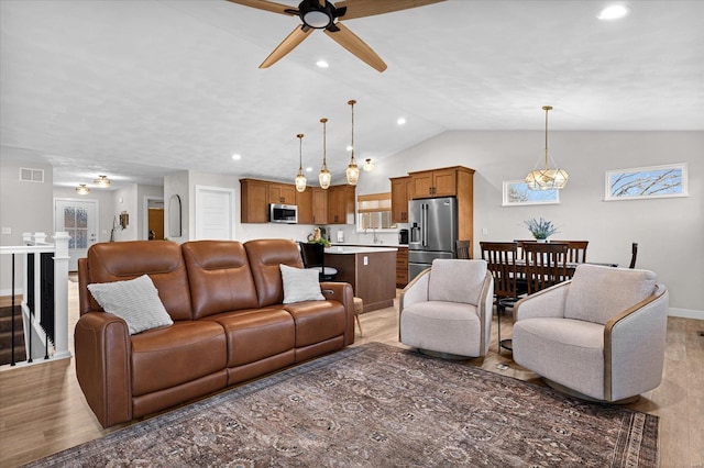 living area featuring ceiling fan, light wood-style floors, vaulted ceiling, recessed lighting, and baseboards