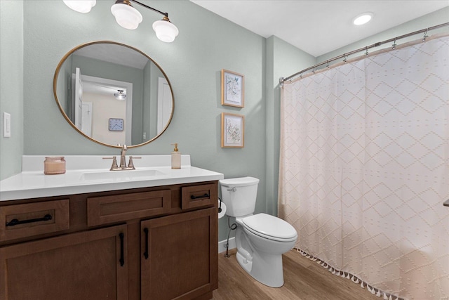 full bathroom with wood finished floors, toilet, vanity, and a shower with shower curtain