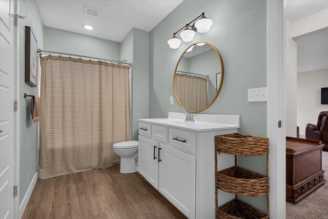 full bathroom with wood finished floors, toilet, vanity, and baseboards