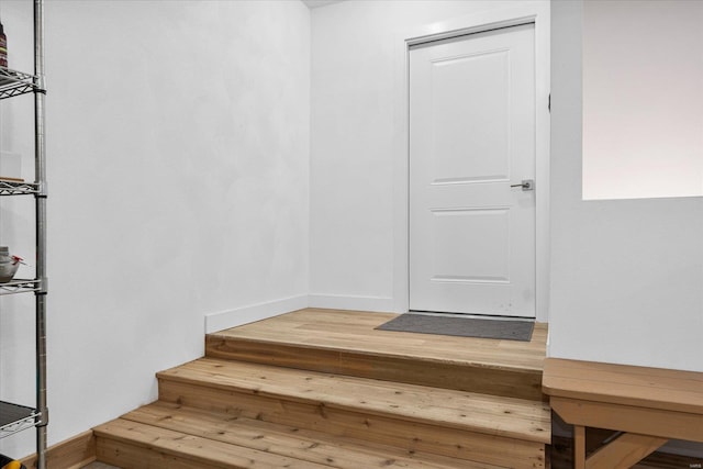 stairs featuring wood finished floors and baseboards