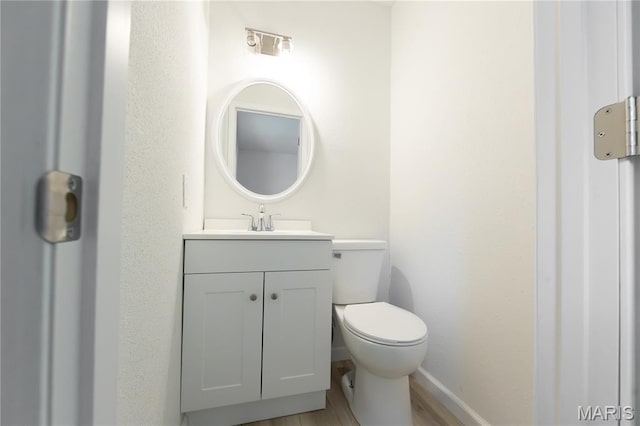 1575 County Road 3290, Salem, MO 65560 - half bathroom featuring vanity, toilet, baseboards, and wood finished floors