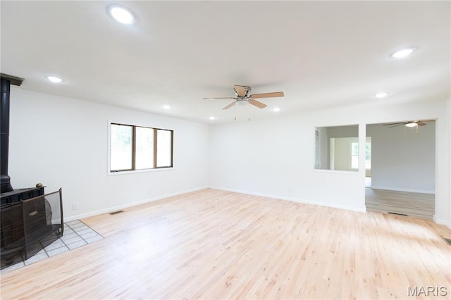 1575 County Road 3290, Salem, MO 65560 - unfurnished living room featuring a wood stove, ceiling fan, light wood finished floors, and recessed lighting