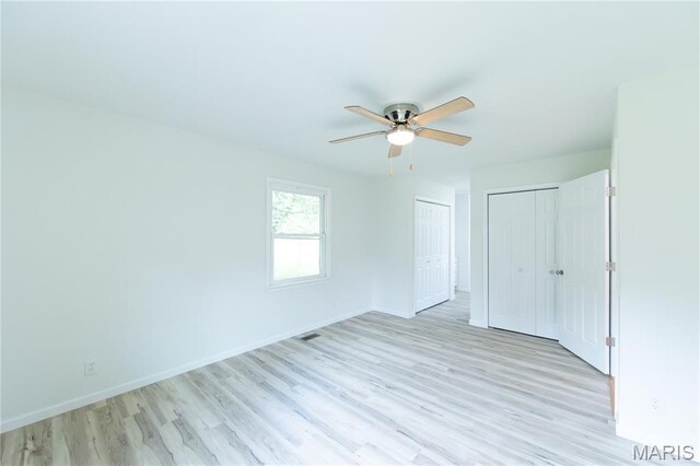 1575 County Road 3290, Salem, MO 65560 - unfurnished bedroom with light wood finished floors, multiple closets, and a ceiling fan