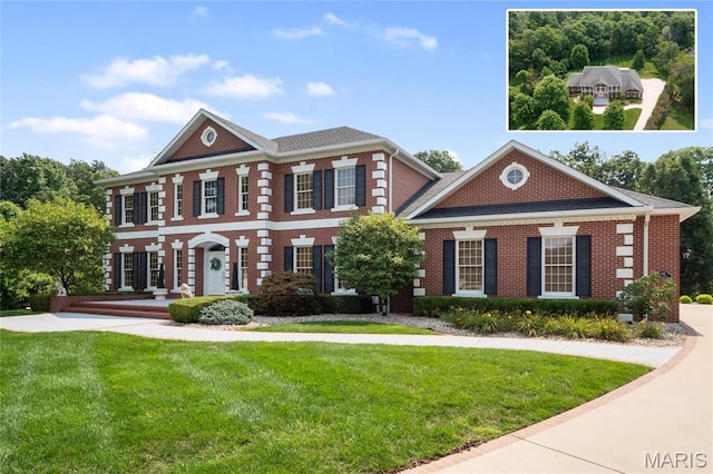 colonial house with brick siding and a front yard