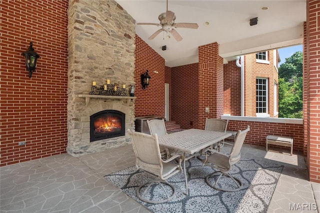view of patio / terrace featuring an outdoor stone fireplace, ceiling fan, and outdoor dining space