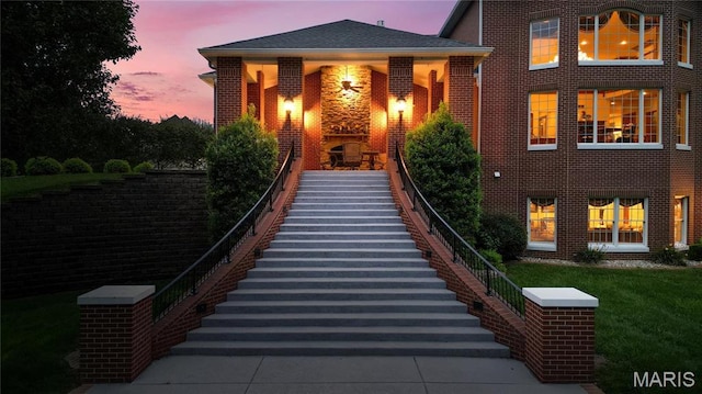 view of front facade featuring stairway and brick siding
