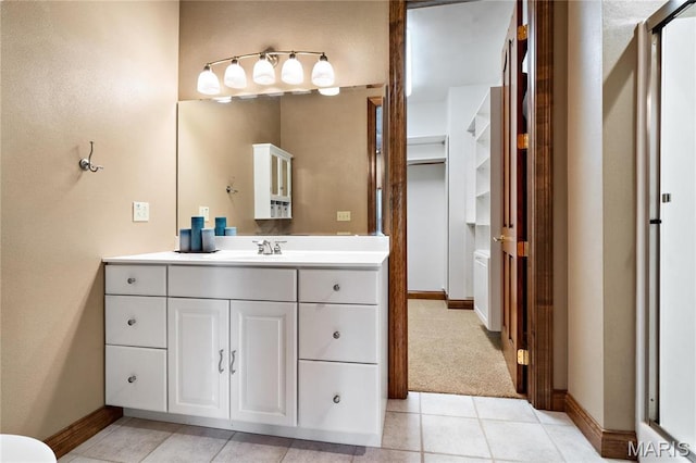 bathroom with baseboards, vanity, and tile patterned flooring
