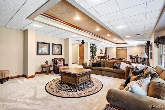 living area with carpet flooring, baseboards, and a drop ceiling