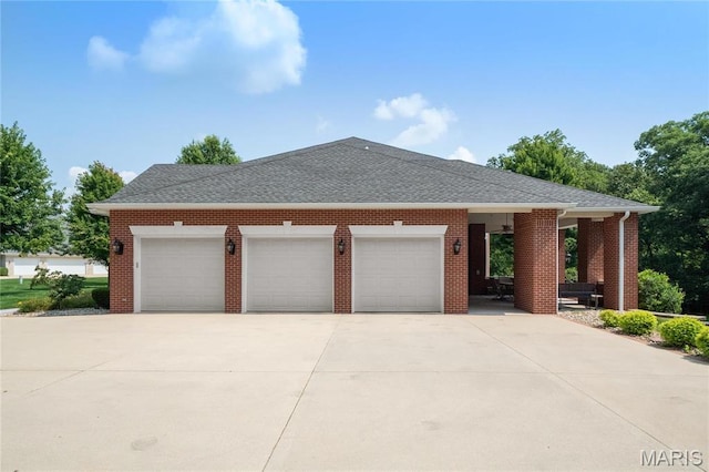 view of front facade featuring an attached garage, driveway, a shingled roof, and brick siding