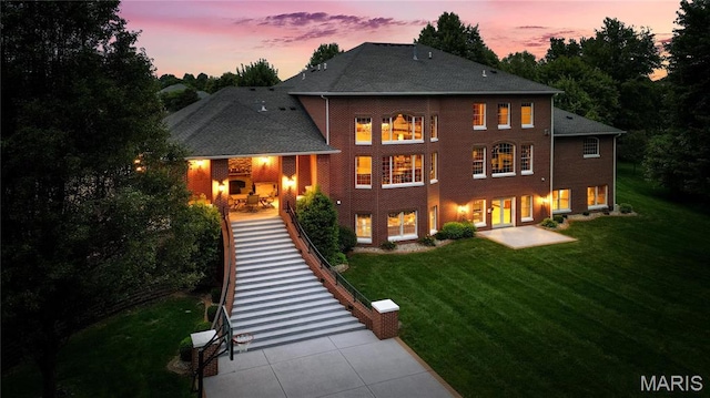 back of property with a lawn and a patio