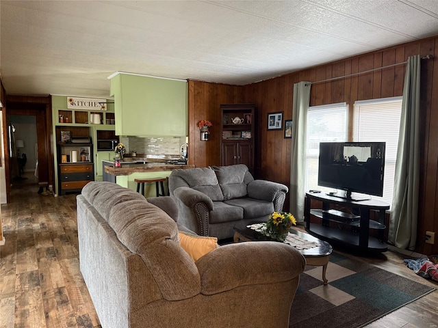living room with wooden walls and dark wood finished floors