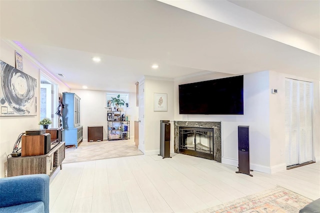 4561 Laclede Ave Unit B, Saint Louis, MO 63108 - living area with a high end fireplace, recessed lighting, ornamental molding, baseboards, and wood finished floors