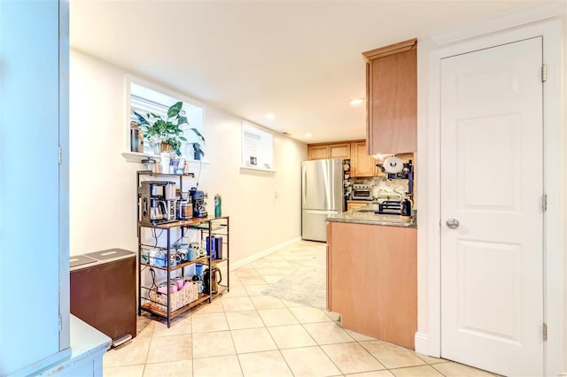 4561 Laclede Ave Unit B, Saint Louis, MO 63108 - kitchen featuring freestanding refrigerator, light brown cabinetry, stove, light countertops, and light tile patterned flooring