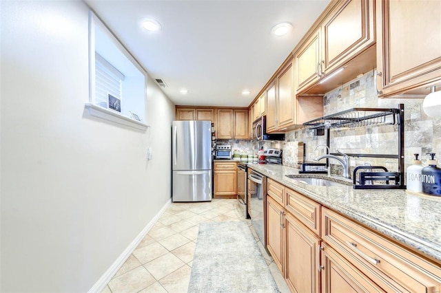 4561 Laclede Ave Unit B, Saint Louis, MO 63108 - kitchen featuring stainless steel appliances, backsplash, a sink, baseboards, and light stone counters