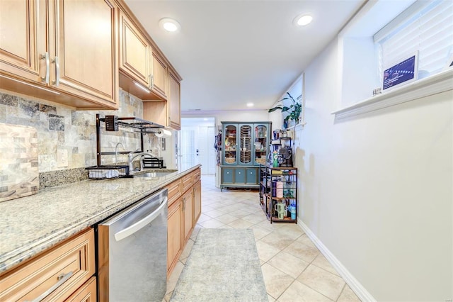 4561 Laclede Ave Unit B, Saint Louis, MO 63108 - kitchen featuring stainless steel dishwasher, light tile patterned floors, backsplash, a sink, and baseboards