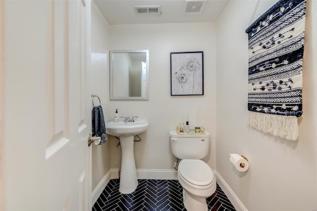 4561 Laclede Ave Unit B, Saint Louis, MO 63108 - half bath featuring toilet, tile patterned flooring, baseboards, and a sink