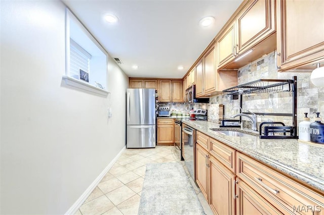 4561 Laclede Ave Unit B, Saint Louis, MO 63108 - kitchen featuring appliances with stainless steel finishes, a sink, decorative backsplash, baseboards, and light tile patterned flooring