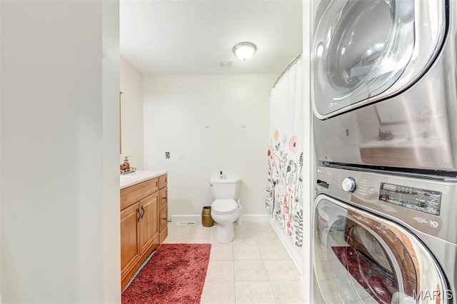 4561 Laclede Ave Unit B, Saint Louis, MO 63108 - full bath featuring estacked washer and dryer, toilet, vanity, baseboards, and tile patterned floors