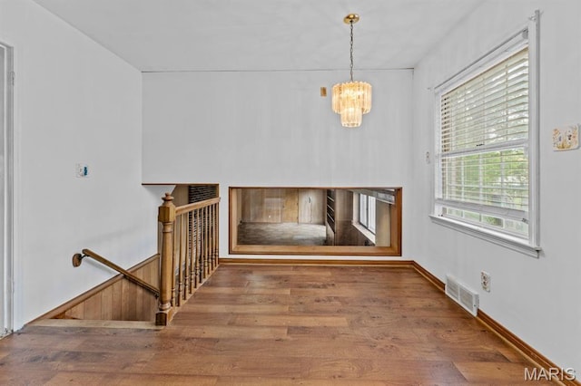 10267 Thornwood Dr, Ladue, MO 63124 - unfurnished living room with wood finished floors and a chandelier