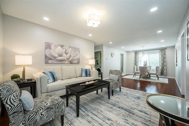 living area featuring wood finished floors, baseboards, recessed lighting, and a chandelier