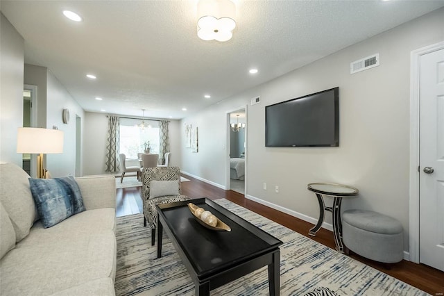 living area with a chandelier, wood finished floors, baseboards, and recessed lighting