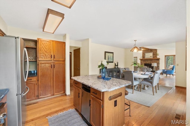 1346 Forest Splendor Trl, Wildwood, MO 63021 - kitchen featuring freestanding refrigerator, light wood-style floors, a center island, a fireplace, and open floor plan