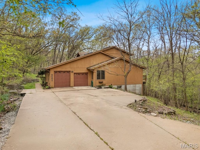 1346 Forest Splendor Trl, Wildwood, MO 63021 - view of front of property featuring a garage, concrete driveway, and a forest view