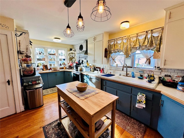 207 S Main St, Licking, MO 65542 - kitchen with stainless steel appliances, blue cabinetry, light wood-type flooring, and decorative backsplash