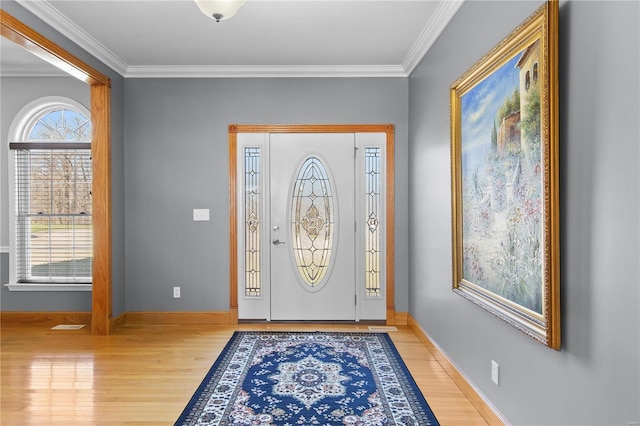 entrance foyer with wood finished floors, ornamental molding, and baseboards