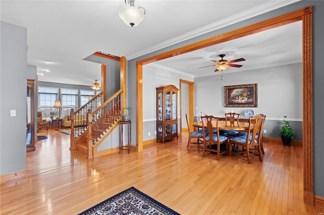 dining area with ceiling fan, hardwood / wood-style floors, stairway, baseboards, and crown molding