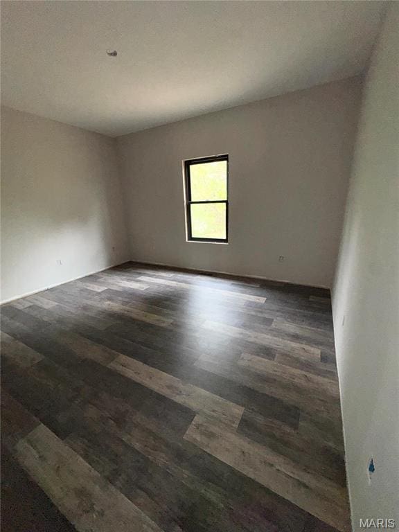 spare room with dark wood-type flooring